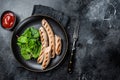 BBQ Grilled pork sausages served with greens. Black background. Top view. Copy space Royalty Free Stock Photo