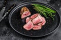 BBQ Grilled sliced lamb tenderloin meat steak on a plate. Black background. Top view Royalty Free Stock Photo