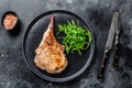 BBQ Grilled tomahawk pork chop meat steak on a marble board. Black background. Top view Royalty Free Stock Photo