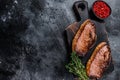 BBQ Grilled top sirloin cap or picanha steak on a wooden cutting board. Black background. Top view. Copy space Royalty Free Stock Photo