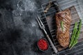 BBQ grilled tri tip beef steak on a grill. Black background. Top view. Copy space Royalty Free Stock Photo