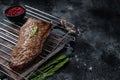 BBQ grilled tri tip beef steak on a grill. Black background. Top view. Copy space Royalty Free Stock Photo