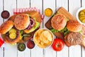 BBQ hamburger table scene, above view over white wood