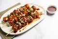 bbq meatball skewers laid out on a marble countertop