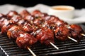 bbq meatball skewers stacked on a metal cooling rack