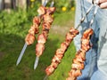 BBQ party concept. A man putting meat on skewers for barbecue. Close-up image of juicy grilled pork or beef on skewers in sunny Royalty Free Stock Photo