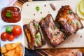 Bbq pork ribs grilled with tomatoes ketchup and herbs spices served on the wooden cutting board on table - Roasted barbecue pork Royalty Free Stock Photo