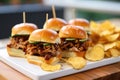 bbq pork sliders on mini artisan buns with a side of spicy chips