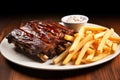 bbq ribs with tangy coleslaw and a mound of fries on a shiny plate