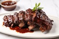 bbq ribs with tangy sauce dripping onto white plate