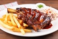 bbq ribs on a white plate with golden fries and coleslaw Royalty Free Stock Photo