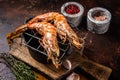 BBQ roasted Giant shrimps Langoustine on grill with herbs. Dark background. Top view