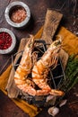 BBQ roasted Giant shrimps Langoustine on grill with herbs. Dark background. Top view