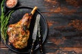 BBq Roasted goat leg. Farm meat. Dark Wooden background. Top view. Copy space