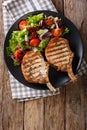 BBQ spicy pork cutlet with mixed salad on a plate close-up. Vert Royalty Free Stock Photo