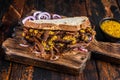 BBQ Texas Sandwich with slow roasted brisket beef meat. Dark wooden background. Top view