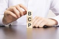 bcp, business continuity plan text on cube blocks in businessman hands, man in white shirt Royalty Free Stock Photo