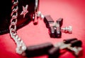 bdsm accessory human collar and accessory nipple clasp with metal chain on a red background close-up