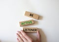 Be active listener symbol. Concept word Be active listener on wooden blocks. Businessman hand. Beautiful white background. Royalty Free Stock Photo