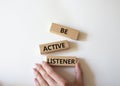 Be active listener symbol. Concept word Be active listener on wooden blocks. Businessman hand. Beautiful white background. Royalty Free Stock Photo