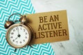 Be An Active Listener text written on paper card with alarm clock on marble background Royalty Free Stock Photo