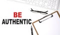 BE AUTHENTIC text written on the white background with keyboard, paper sheet and pen Royalty Free Stock Photo