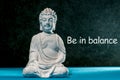 Be in balance - inspiration phrase with little white meditate buddha. Zen, yoga and life concept Royalty Free Stock Photo