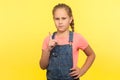 Be careful! Portrait of smart bossy little girl in denim overalls standing with admonishing gesture Royalty Free Stock Photo