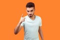 Be careful! Portrait of strict bossy brunette man warning you with raised finger gesture. indoor studio shot isolated on orange