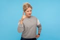 Be careful! Serious angry woman with short curly hair in sweatshirt warning with raised finger, admonishing gesture Royalty Free Stock Photo