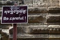 Be careful sign in stone ruin of Angkor Wat complex, Cambodia. Old stone stair with stone carving decor. Royalty Free Stock Photo