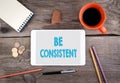 Be Consistent. Tablet device on a wooden table