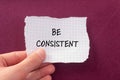 Be consistent words written on torn paper with purple background