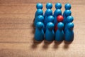 Be different, red among blue figurines Royalty Free Stock Photo