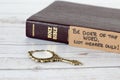 Be doer of the Word, not hearer only, handwritten verse with holy bible book and antique golden mirror on wooden table, a closeup