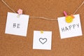 Be happy handwriting on white three papers fastened with flower and yellow fish mandala and pushpin on cork board