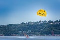 Be happy. Tourists parasailing with a happy face parachute on the coast of Seattle