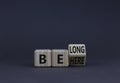Be here belong symbol. Turned a wooden cube and changed concept words Be here to Belong. Beautiful grey background. Business,