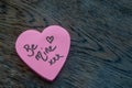 Be Mine hand wrote text on pink love heart with drawn hearts. On rustic wooden background. Love Valentines concept