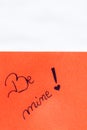 Be mine handwriting text close up isolated on orange paper with copy space. Writing text on memo post reminder