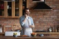 Millennial man cooking healthy salad talk on phone at kitchen Royalty Free Stock Photo