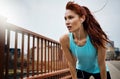 Be patient and persistent while you progress. a sporty young woman taking a break while running in the city. Royalty Free Stock Photo