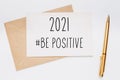 2021 be positive note with envelope and gold pen on white background. merry christmas and New Year concept