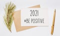 2021 be positive note with envelope spruce branch and gold pen on white background. merry christmas and New Year concept