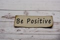 Be positive text on burnt edge brown paper