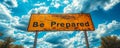 Be Prepared sign in bold lettering on a cautionary yellow traffic sign against a backdrop of blue sky with fluffy white