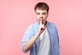 Be quiet! Portrait of young brown-haired man with small beard and mustache making silence gesture. indoor studio shot isolated on