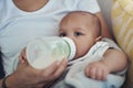 Be right back, having a bottle. an adorable baby girl being bottle fed by her mother on the sofa at home. Royalty Free Stock Photo