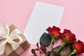Be romantic...Top view of gift set for her: fresh red roses, gift box and paper note for love letter Royalty Free Stock Photo