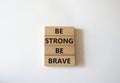 Be strong be brave symbol. Concept words Be strong be brave on wooden blocks. Beautiful white background. Business concept. Copy